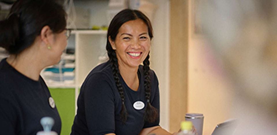 Smilende medarbejder til teammøde