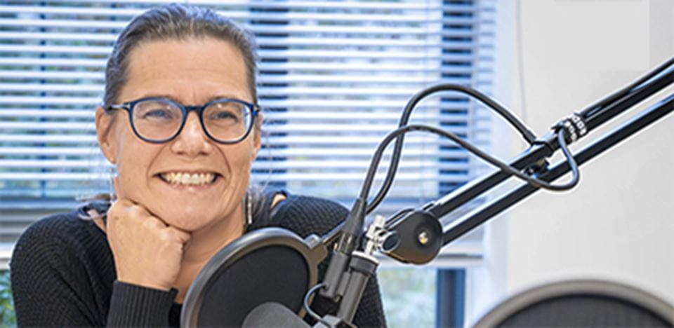 Kvinde smiler foran mikrofon